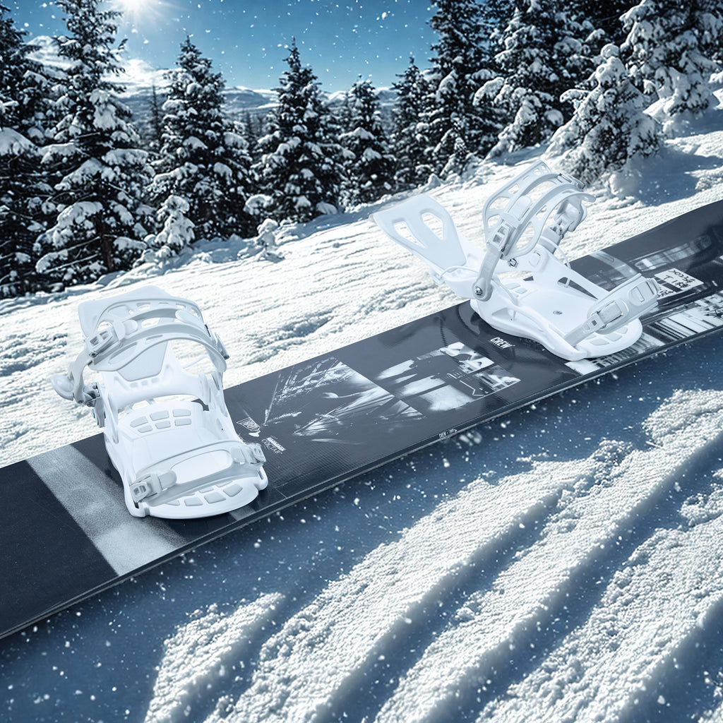 A snowboard equipped with XCMAN 360 Seco white bindings resting on fresh snow in a winter resort setting
